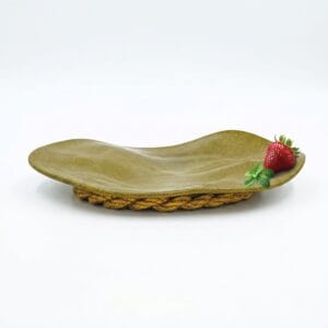 Wabi sabi stoneware celadon plate sitting elegantly on its braided hemp rope